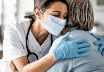 nurse hugging an elderly lady